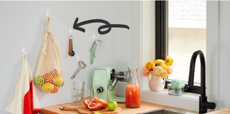  Tips de organización sin herramientas: Organización de utensilios de cocina con ganchos blancos adhesivos Command.